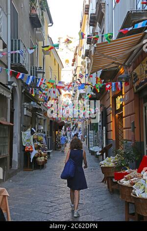 Sorrento, Italy - June 26, 2014: People WAlking at Narrow Street With Flags Decoration in Sorrento, Italy. Stock Photo