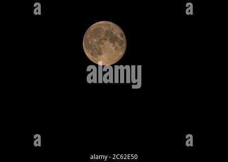 The full moon moves through the night sky Stock Photo