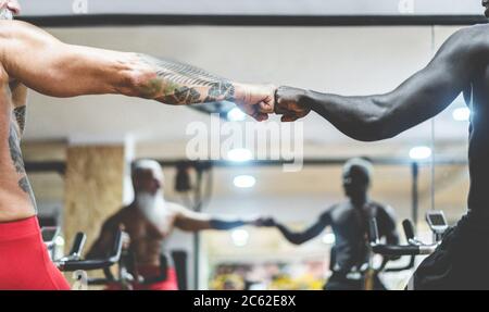 People from different generation and ethnicities doing workout session on cardio cyclette inside gym club - Fitness, spinning, no racism and sport con Stock Photo