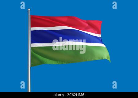 Gambia flag waving in the deep blue sky background. Isolated national ...