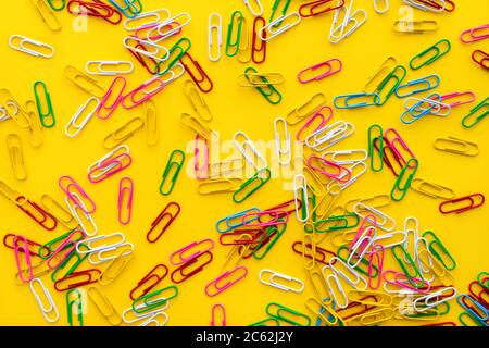 Education and back to school concept. Colourful paper clips on bright yellow background. Stock Photo