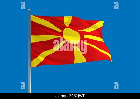 Macedonia national flag waving in the wind on a deep blue sky. High quality fabric. International relations concept. Stock Photo