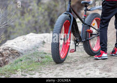 Close-up of the man wearing red and black clothes and standing near the bicycle. Sport idea concept Stock Photo
