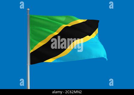 Tanzania flag waving in the deep blue sky background. Isolated national ...