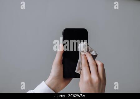 Cleaning the smartphone screen with a fiber cloth. Stock Photo