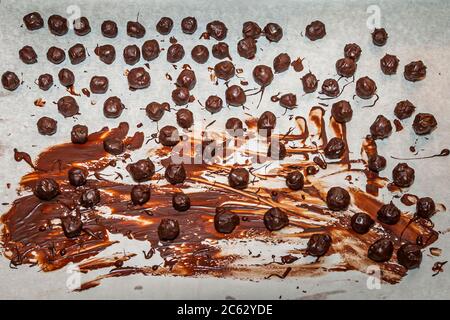 Rows of finished truffle balls sit ready to dry on chocolate-smeared baking paper at the chocolate truffle workshop "Peter sei selig – Genusspunkt Küche" in Grevenbroich, Germany. Stock Photo