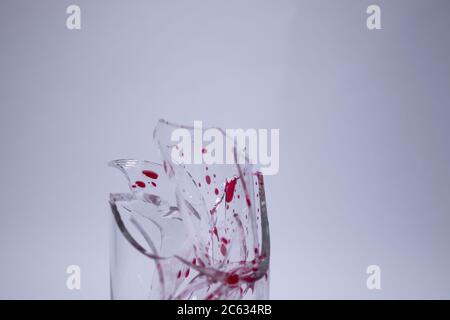 drops of red liquid - blood - on the fragments of a broken glass in a broken glass on a white background. Isolated. Copy space. pain concept. High quality photo Stock Photo