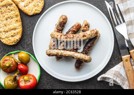 Grilled white sausages on plate. Top view.