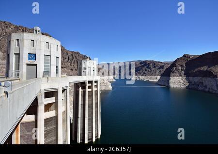 The two Intake Towers on the Nevada side of the Hoover Dam. Waterline is visible on the walls of the canyon and a clock displays the Nevada Time. Stock Photo