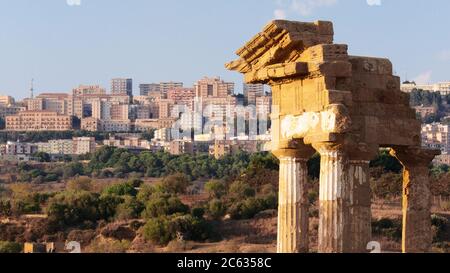 concept old-new of temple in the Valley of Temples and on background the modern apartment block in Agrigento town of Sicily tourism landmark Stock Photo
