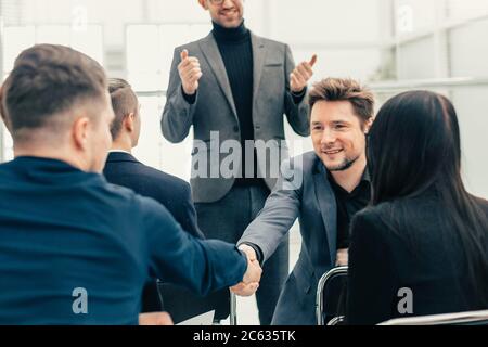 smiling employees shaking hands during a working meeting Stock Photo