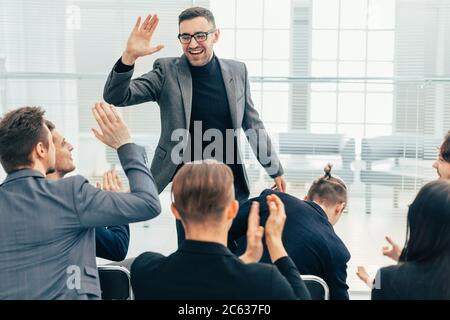 employees giving each other a high five during a work meeting Stock Photo