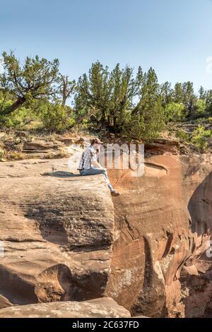 Man sitting on the edge of a cliff, Palo Duro Canyin State Park, Texas Stock Photo