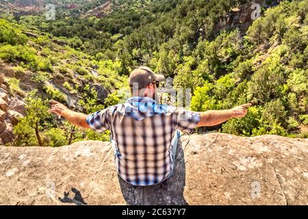 Man sitting on the edge of a cliff, Palo Duro Canyin State Park, Texas Stock Photo