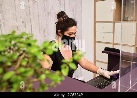 woman managing the reception of your business by answering the phone and making an appointment Stock Photo