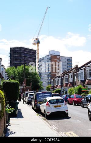 A changing Suburban skyline, a Tower crane hard at work building new flats Stock Photo