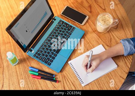 Coronavirus. Person making notes while working at home during quarantine..Top View Stock Photo