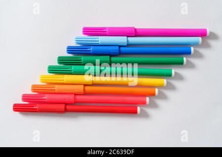 Colored markers on a white sheet. Top view. Stock Photo