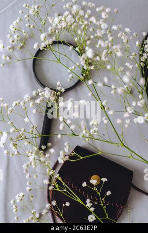 A purse for coins and a magnifying glass on gray fabric. Stock Photo
