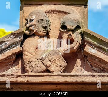 Stone figure of a man holding a skull, a detail from a gravestone in East Lothian, Scotland, UK. Stock Photo