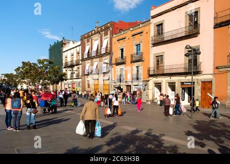 People and colorful old buildings next to the Zocalo at Mexico City historic center Stock Photo