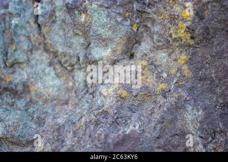 The background is the texture of a stone rock. partially blurred image. Blue stone with golden inclusions. Stock Photo
