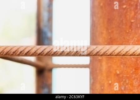 macro of corrosion-textured vintage rusty metal pole, rusty metal fence close-up sunlit. Stock Photo