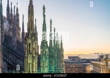 The stretched statue pillars on the top of the Cathedral in Milan before the sunset Stock Photo
