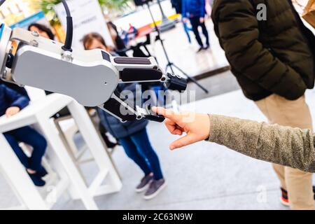 A robot arm played with a child in an innovative engineering and industry exhibition. Stock Photo