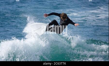 Teenage boy surfer jumping high on a cutback Stock Photo