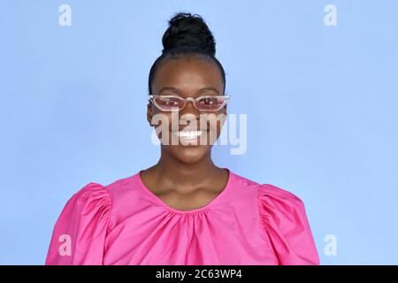 Happy african woman wearing trendy cloth and pink sunglasses isolated on lilac. Stock Photo