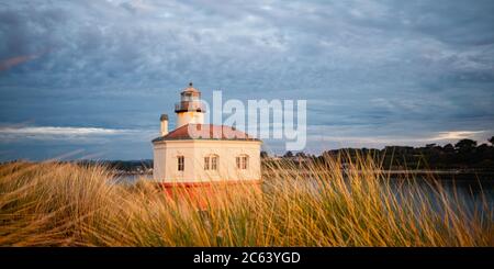 Coquille River Lighthouse in Bandon illuminated by setting sun, Oregon Stock Photo