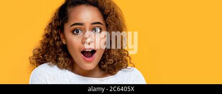 Surprised mixed African woman gasping isolated on yellow banner background with copy space Stock Photo