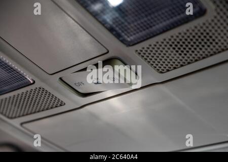 A switch on the roof of a car controlling the behavior of the interior lighting is switched to the "off" position. Stock Photo