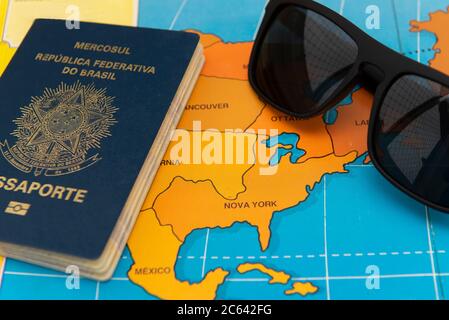 Florianopolis, Brazil. June 27, 2020: Top view of Brazilian passport over map. Focus on the North American continent. Emigration, travel, destination Stock Photo