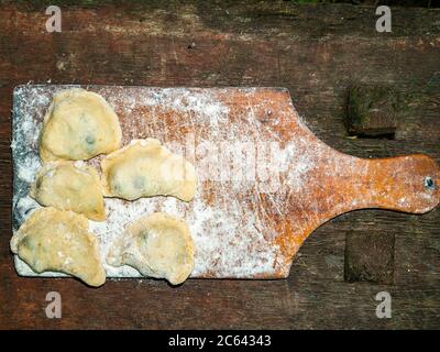 Ukrainian dumplings with dough stuffed on a cutting board. Stock Photo