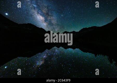 The Milky Way rises and reflects over Bear Creek Spire in the Little Lakes Valley. Stock Photo