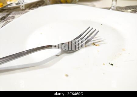 White empty plate with fork after meal Stock Photo