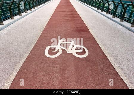 Closeup photo of a bicycle symbol on the city bike path. Cycle track road sign on the bridge. Stock Photo