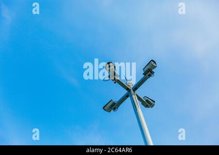 Surveillance camera mounted on a pillar under a blue sky Stock Photo