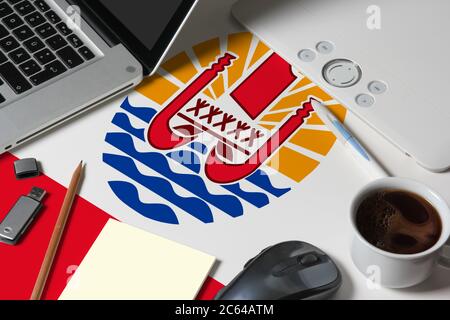 French Polynesia national flag on top view work space of creative designer with laptop, computer keyboard, usb drive, graphic tablet, coffee cup, mous Stock Photo