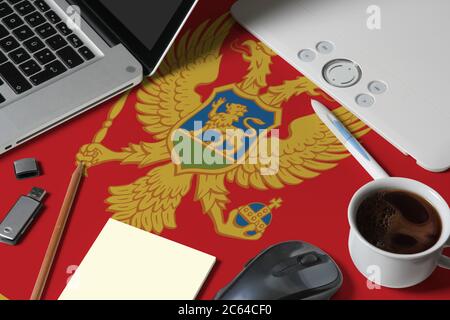 Montenegro national flag on top view work space of creative designer with laptop, computer keyboard, usb drive, graphic tablet, coffee cup, mouse on w Stock Photo