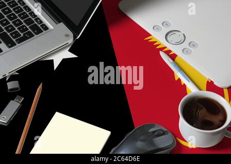 Papua New Guinea national flag on top view work space of creative designer with laptop, computer keyboard, usb drive, graphic tablet, coffee cup, mous Stock Photo
