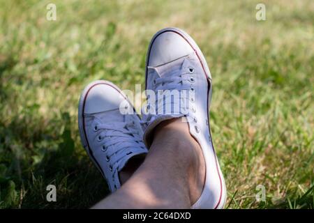 white dirty sneakers on grass Stock Photo