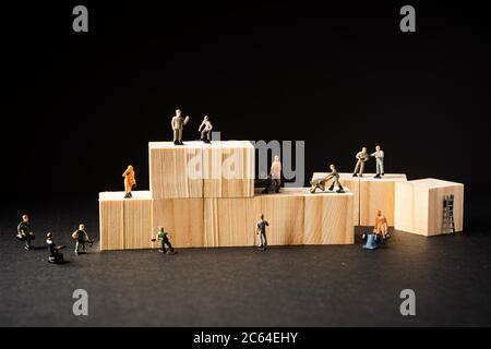 Miniature Builder Figures with wooden blocks, Labour Day Concept Stock Photo