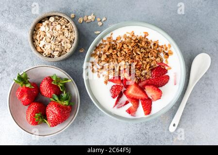 Yogurt with strawberries and granola in bowl. Homemade granola with fresh strawberries and natural greek yogurt. Healthy breakfast food top view Stock Photo