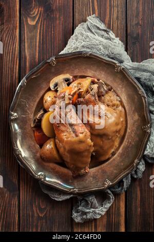 Stewed rabbit legs with vegetables on a plate Stock Photo