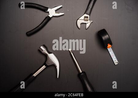 Flat lay composition of a set of tools, including hammer, pliers, wrench, screwdrivers and measuring tape. Top view, concept for father’s day, includi Stock Photo