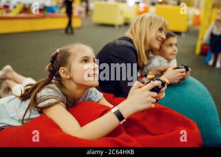 Children plays game console, entertainment center Stock Photo