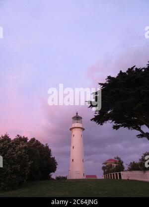 Lighthouse on Tiritiri Matangi Island in the Hauraki Gulf, New Zealand. During purple colored sunset. Stock Photo